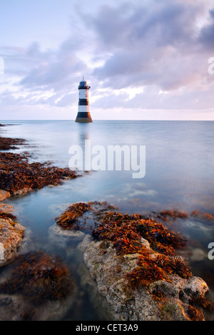 Una vista di Penmon Faro all'alba sulla costa di Anglesey nel Galles del Nord. Foto Stock