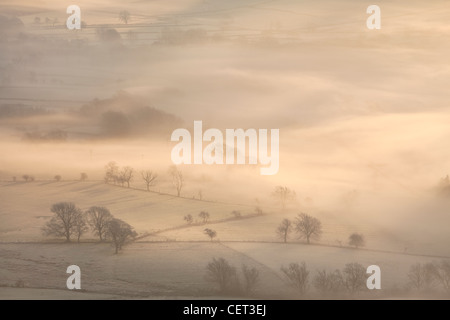 La Hope Valley è avvolta nella nebbia all'alba nel Parco Nazionale di Peak District. Foto Stock