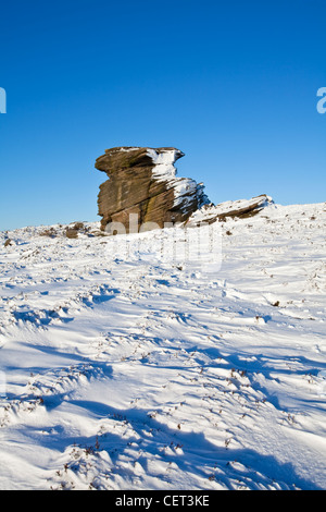 Sulla neve e madre circostante il tappo, una grande roccia gritstone formazione nel Parco Nazionale di Peak District. Foto Stock