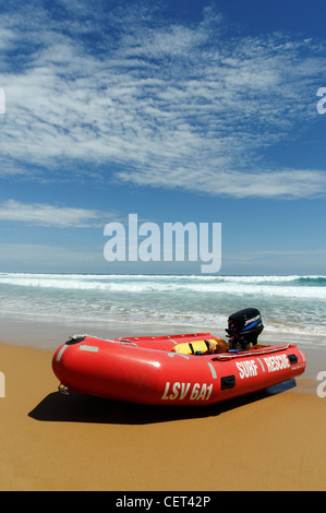 Un rosso surf rescue zodiac tirata su una spiaggia Foto Stock