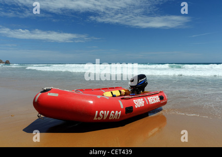 Un rosso surf rescue zodiac tirata su una spiaggia Foto Stock