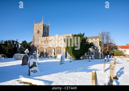 La tradizionale pietra focaia chiesa di St Mary nel villaggio di Stratford Santa Maria dopo un pesante nevicate invernali. Foto Stock
