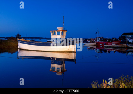 Barche da pesca si riflette ancora in acqua durante la notte sulla costa di Norfolk. Foto Stock