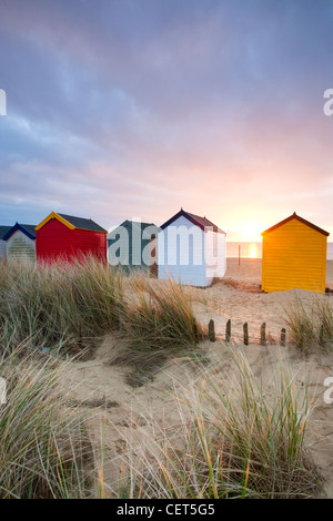 Alba sopra le dune di sabbia e pittoresca spiaggia di capanne lungo il lungomare di Southwold sulla costa di Suffolk. Foto Stock