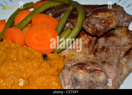 Bistecche di carne di agnello con zucca carote e fagioli Foto Stock