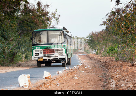 Indian bus / pullman passando per le riparazioni stradali in zone rurali campagna indiana. Andhra Pradesh, India Foto Stock