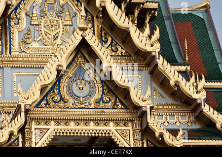 Il tetto dorato del Phra Thinang Chakri Maha Prasat trono Hall Grand Palace di Bangkok in Thailandia con il Royal emblemi - dettaglio Foto Stock