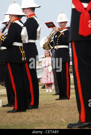 La ragazza è fiore abito ascoltando la banda militare a Goodwood. Foto Stock