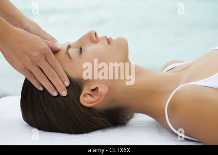 Giovane donna riceve il massaggio del viso, vista laterale Foto Stock