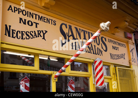 Nel Regno Unito, in Galles, Swansea, vento Street, tradizionale striped barbieri pole e segno esterno della Santino parrucchieri Foto Stock
