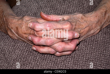 Mani giunte di una signora anziana Foto Stock