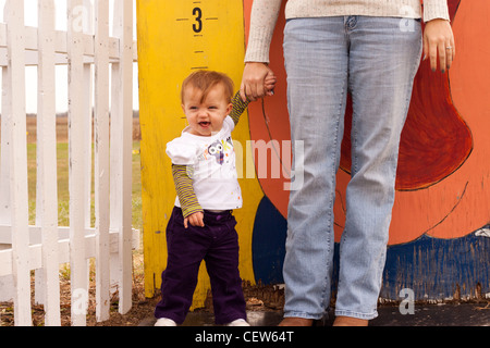 Bambino Piccolo di altezza essendo misurata a un parco all'aperto Foto Stock