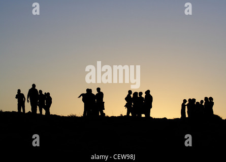 Gruppi di persone in silhouette al tramonto. Può essere utilizzato come concetto di stile di vita foto che illustra l'interazione sociale, la separazione tra i gruppi etc. Foto Stock