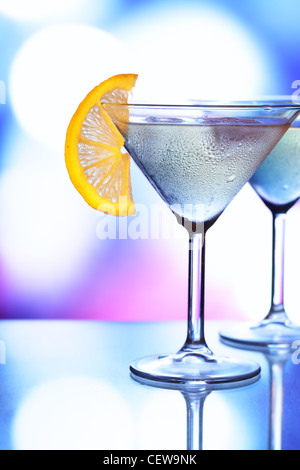 Bicchieri da cocktail con ghiaccio e luci delle vacanze in background Foto Stock