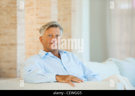 Senior uomo seduto sul divano, ritratto Foto Stock