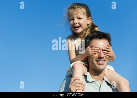 Ragazza di copertura del padre gli occhi con le mani Foto Stock