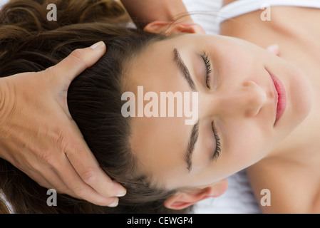Giovane donna ricevere massaggio della testa Foto Stock