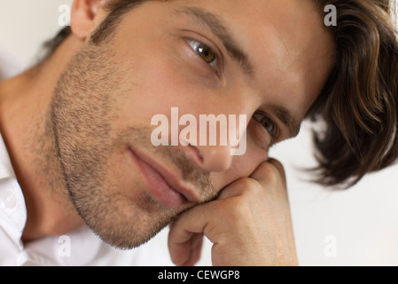 Uomo appoggiato la testa sulla mano, fantasticando Foto Stock