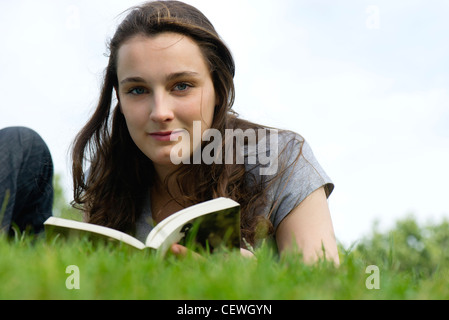 Giovane donna di relax all'aperto con Libro, ritratto Foto Stock