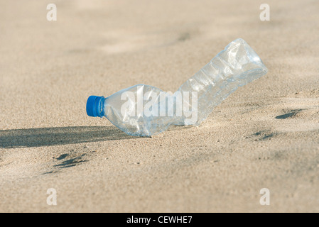 Svuotare la bottiglia di plastica sulla spiaggia, close-up