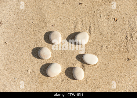 Ciottoli disposti in cerchio sulla sabbia Foto Stock