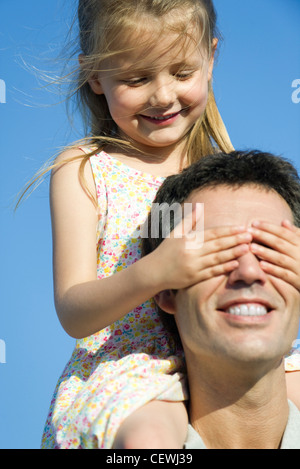 Ragazza di copertura del padre gli occhi con le mani Foto Stock