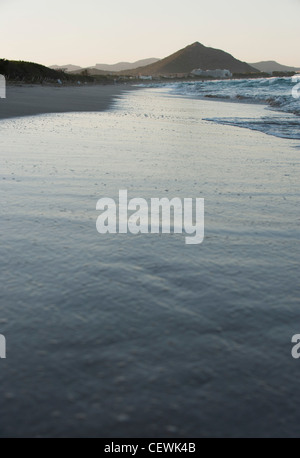 Sciabordare di onde sulla spiaggia Foto Stock