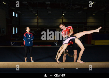 Ginnasta femmina praticando sul fascio di equilibrio con pullman Foto Stock