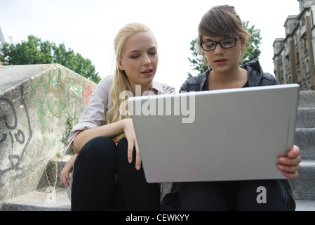 Giovani donne che utilizzano computer notebook all'aperto Foto Stock