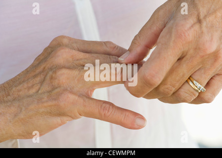 Senior donna sfregamento knuckles, ritagliato Foto Stock
