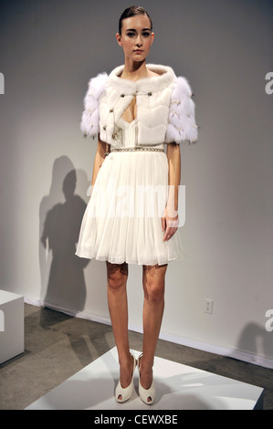 J Mendel New York pronto a indossare Primavera Estate modello indossando un bianco abito riuniti, ritagliata ermellino bianco mantello di pelliccia, un imbuto Foto Stock