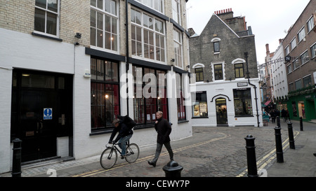 Negozi alla moda, ciclisti e pedoni a Newburgh Street vicino a Carnaby Street nel quartiere Newburgh London Inghilterra England Foto Stock