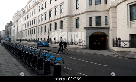 Un uomo rallentare per parcheggiare la sua bicicletta in un ciclo di Barclays cremagliera sul William IV Street a Londra England Regno Unito KATHY DEWITT Foto Stock