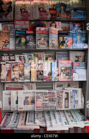 Pubblicazioni internazionali, riviste e quotidiani su scaffali per espositori cartacei presso un edicola a Londra Inghilterra Regno Unito KATHY DEWITT Foto Stock