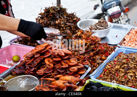 Un mercato in stallo in Phnom Penh Cambogia vendita di deep-snack fritti come serpenti, rane, scarafaggi e granchi Foto Stock