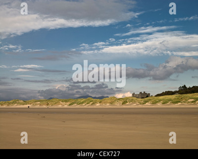 Vista di Harlech Castle da Harlech beach. Il mare si è ritirato nel corso degli anni ma utilizzato per venire ai piedi delle falesie providi Foto Stock
