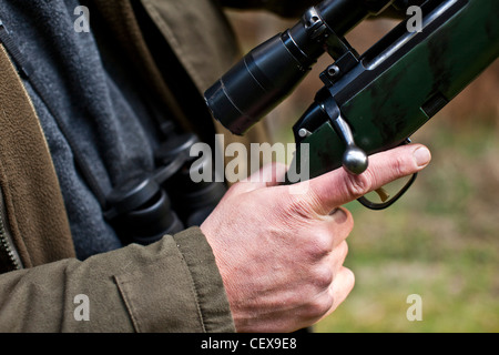 Uomo con il dito sul grilletto della pistola, a caccia di cervi a Thetford Forest, Regno Unito Foto Stock