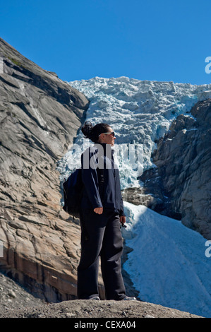 Turista femminile. Briksdalbreen Ghiacciaio Briksdal vicino Olden Stryn Sogn og Fjordane Norvegia Foto Stock