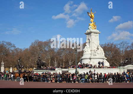 Una folla di persone intorno al Queen Victoria Memorial in attesa di visualizzare il cambio della guardia sfilata a Buckingham Palace. Foto Stock