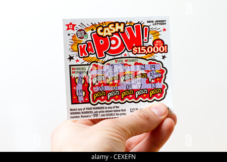 Tenendo la mano vincente lotteria scratch card di un New Jersey lottery Foto Stock