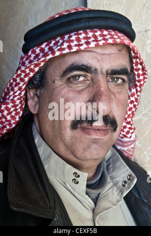 Un ritratto di un uomo beduino arabo della città di al-Azraq che indossa un copricapo a scacchi rossi, nella regione Badia del deserto orientale della Giordania. Foto Stock