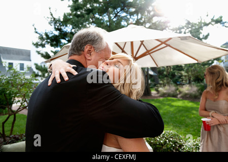 Padre abbracciando la sua figlia il suo giorno di nozze Foto Stock