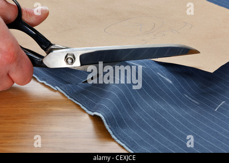 Foto di un pezzo di materiale gessato essendo tagliato intorno a un modello su misura Foto Stock