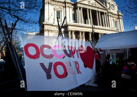 Tende e segni contenenti slogan a occupare Londra LSX sito di protesta a San Paolo, Londra, Regno Unito. Foto Stock