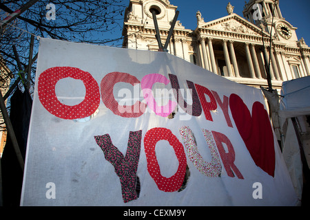 Tende e segni contenenti slogan a occupare Londra LSX sito di protesta a San Paolo, Londra, Regno Unito. Foto Stock