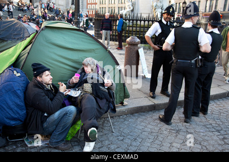 Tende e segni contenenti slogan a occupare Londra LSX sito di protesta a San Paolo, Londra, Regno Unito. Foto Stock