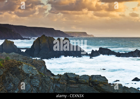 Impostare il tramonto sull'Oceano Atlantico, guardando fuori da Hartland Quay sulla North Devon Coast, Inghilterra Foto Stock