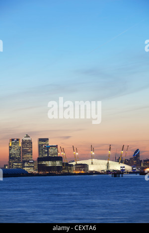 Una vista verso il basso th fiume Tamigi verso la città di Londra e la O2 Arena, Canary Wharf al tramonto Foto Stock