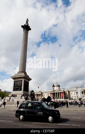 Una vista di un Black Cab come si passa di fronte alla National Portrait Galllery e Nelson la colonna a Trafalgar Square Foto Stock