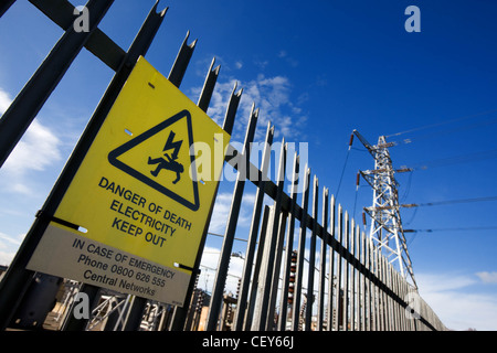 La recinzione di sicurezza su un elettricità stazione secondaria con pericolo di morte segno Foto Stock
